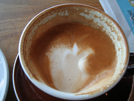 Photo of a half-full flat white taken in the Wellington Airport in New Zealand.
